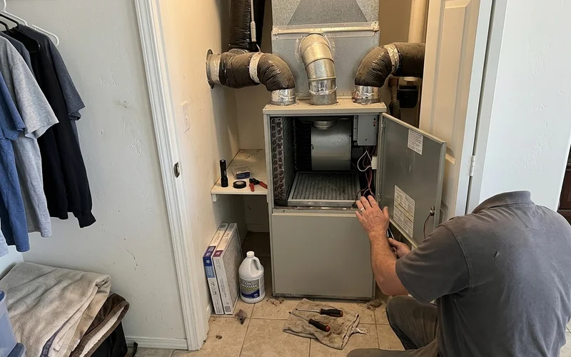 Indoor air handler in a closet with ductwork visible above