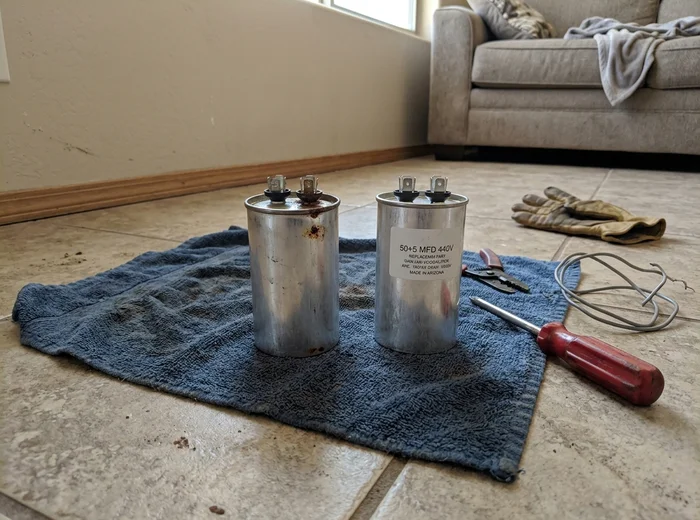 Failed dual run capacitor beside its replacement