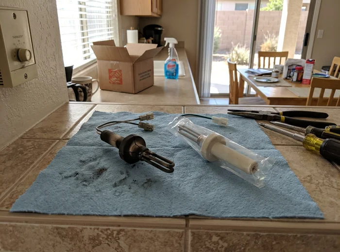 Failed hot surface ignitor beside a new replacement