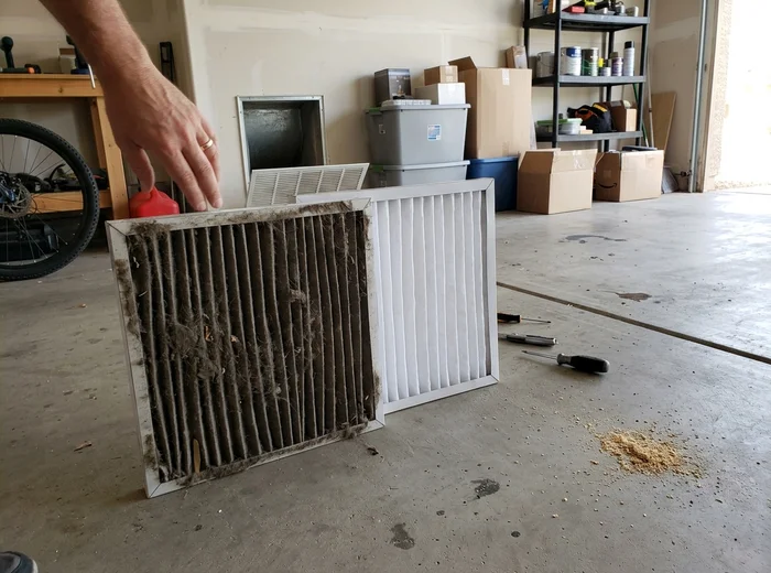 Dirty air filter beside its clean replacement