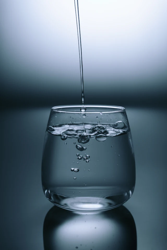 Filtered drinking water being poured into a clear glass